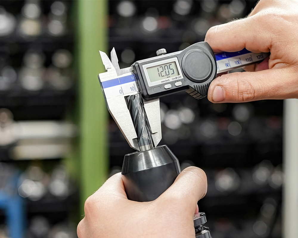Engineer measuring a workpiece with a caliper